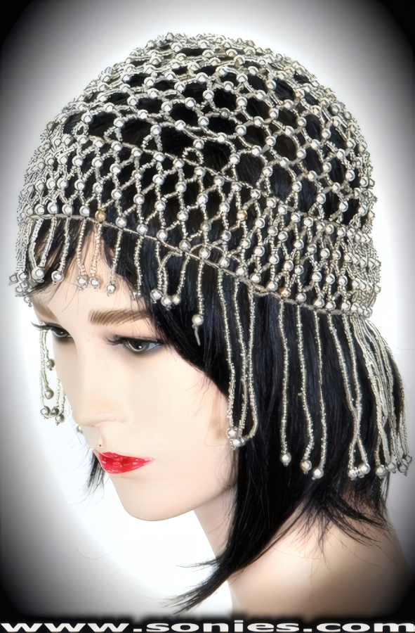 Blissful contentment wearing this dramatic Reventador Egyptian-style headpiece that is splendidly crafted to liven up any outfit. Hand woven with small and large iridescent beads. Finished with detailed short on front and long on back beaded fringe.   Style: BTBC-01