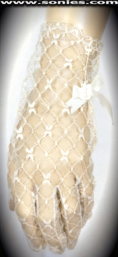 Show him you've got what it takes in these luxurious Jovis wrist length floral lace and metallic yarn gloves. Side seamed cuff with satin bow and pearl detail finish. Dainty lace gloves have a playful ambiance, much more so than formal opera length gloves. This style is perfect for formal, bridal, prom, d�butante and Opera Ball.   Style: MFG-72818