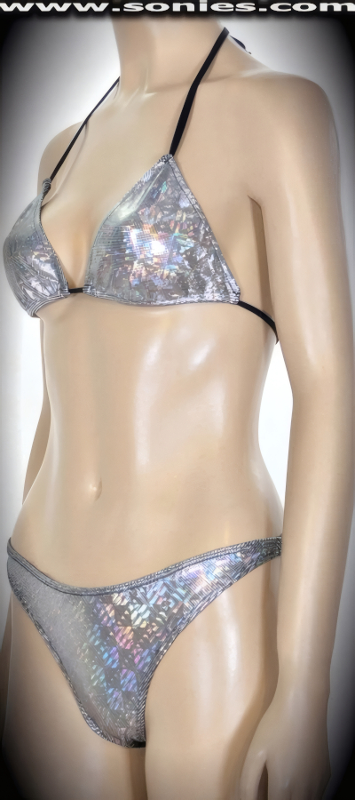 Flaunt your curves in this sexy Out of this Galaxy dizzy silver glitter stretch hologram Lycra two piece bikini set. Adjustable slide and tie triangle top for minimal or maximum coverage and is designed to fit all busts. Halter straps tie around neck and back to ensure a great fit. Complementing thong back bottom with lined crotch, sleek scoop front, plus side clasp closures for off and on ease. Created using four way stretch hologram Lycra fabric to trace your bodies contour and offers a stunning effect under any lighting (15% Lycra, 85% Nylon. Wash delicate and hang dry. Exposure to salt water and chlorine not recommended). May be worn with stiletto heel shoes to create a phenomenal look. This style is perfect for professional exotic dancers, life style events, pride week, monthly play parties, fetish events, adult alternative lifestyle gatherings, bachelor parties, club wear, gentleman's clubs, and to grab serious attention when worn at the beach or lounging at the pool.   Style: SC-3